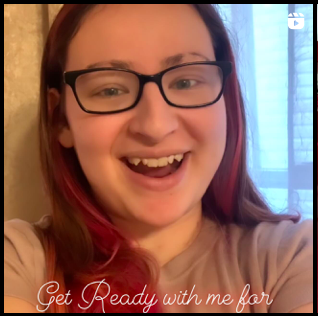 A girl with pink hair, glasses, and a big smile on her face holds the camera selfie style. The words on the bottom read "Get Ready With Me" in pink neon text.